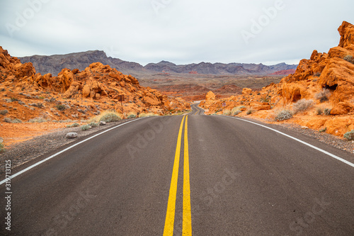 Desert road with red rocky landscape in Valley of Fire State Park, USA