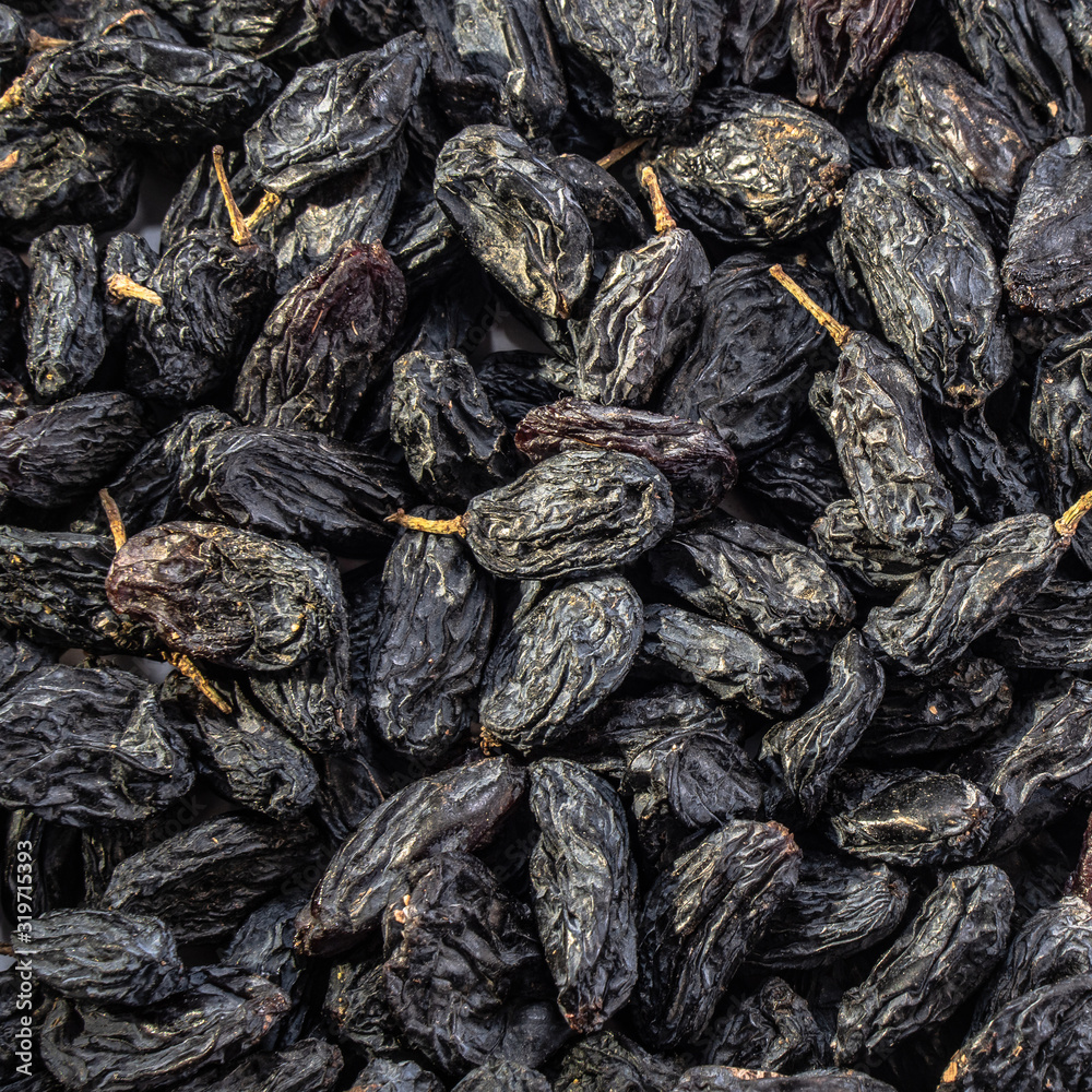 Dark raisins on a white isolated background. Food brown-blue grapes delicious for your design for the site. kitchen theme