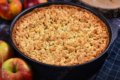 Foto Whole traditional European apple pie with topping crumbles in springform pan