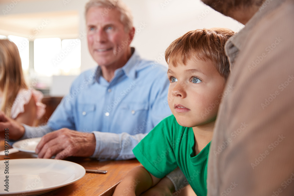 Multi-Generation Family Sitting Around Table Enjoying Meal At Home Together Multi-Generation Family Sitting Around Table Enjoying Meal At Home Together