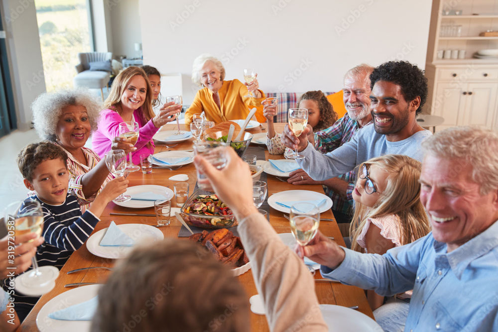 Multi-Generation Family Making A Toast With Wine As They Meet For Meal At Home Multi-Generation Family Making A Toast With Wine As They Meet For Meal At Home