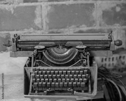 Black and white photo. Old, antique typewriter close-up in the dust.