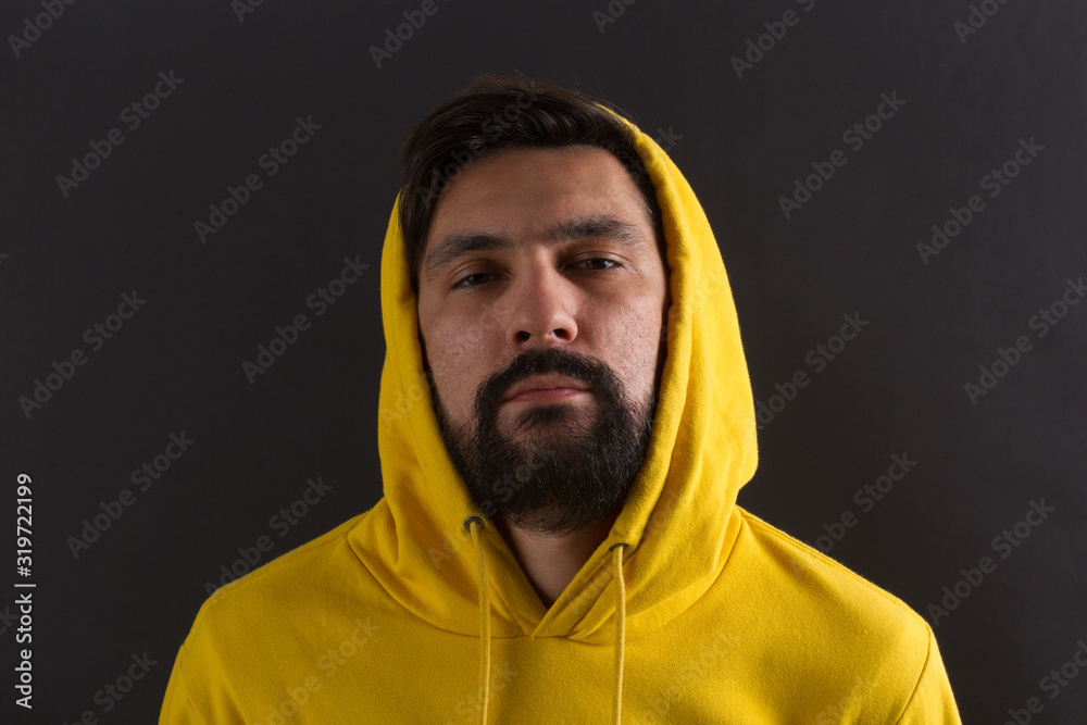 man in a yellow sweatshirt on a dark background man in a yellow sweatshirt on a dark background
