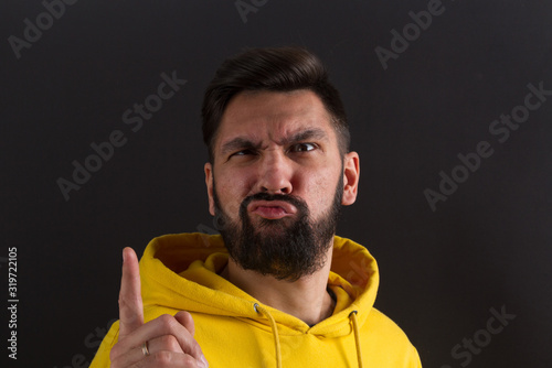 man in a yellow sweatshirt on a dark background