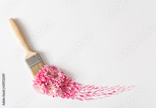 Flowers composition. Creative layout made of pink and white flowers and paint brush on white background. Flat lay, top view, copy space.