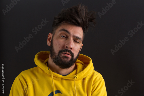 man in a yellow sweatshirt on a dark background