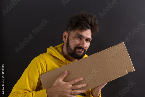 man in a yellow sweatshirt on a dark background