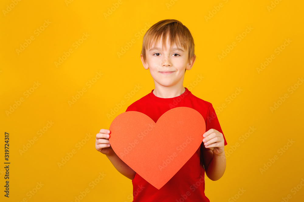 Cute smiling boy holding red paper heart. Child giving valentines heart. Love mood Cute smiling boy holding red paper heart. Child giving valentines heart. Love mood