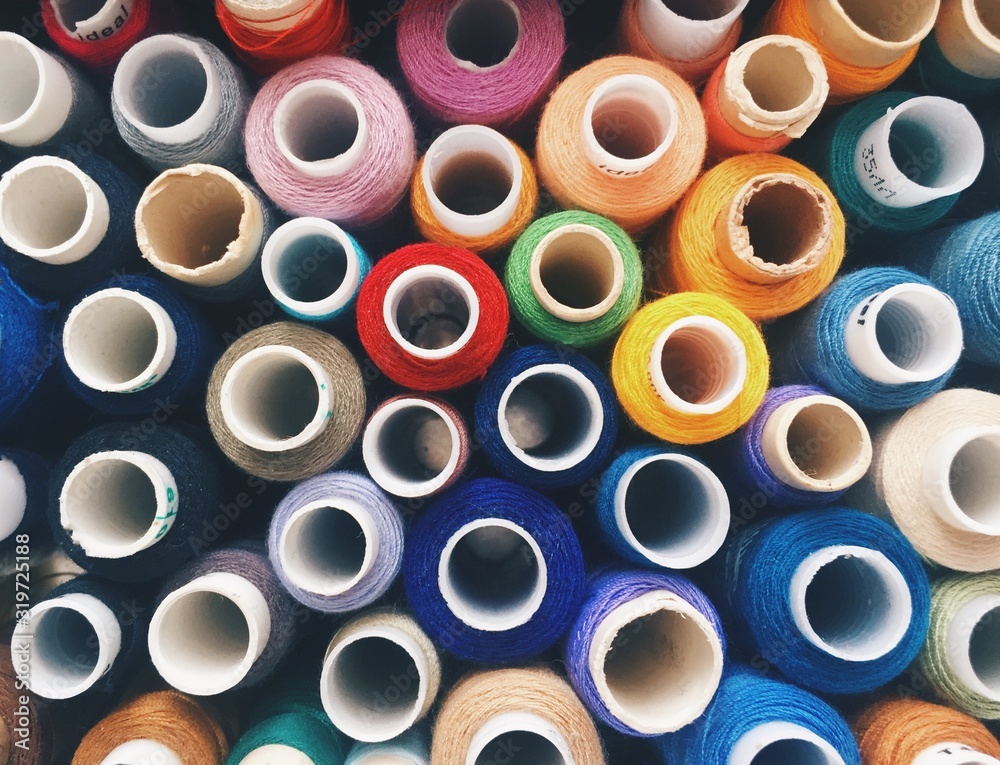 Tops of coils of colorful sewing threads Tops of coils of colorful sewing threads