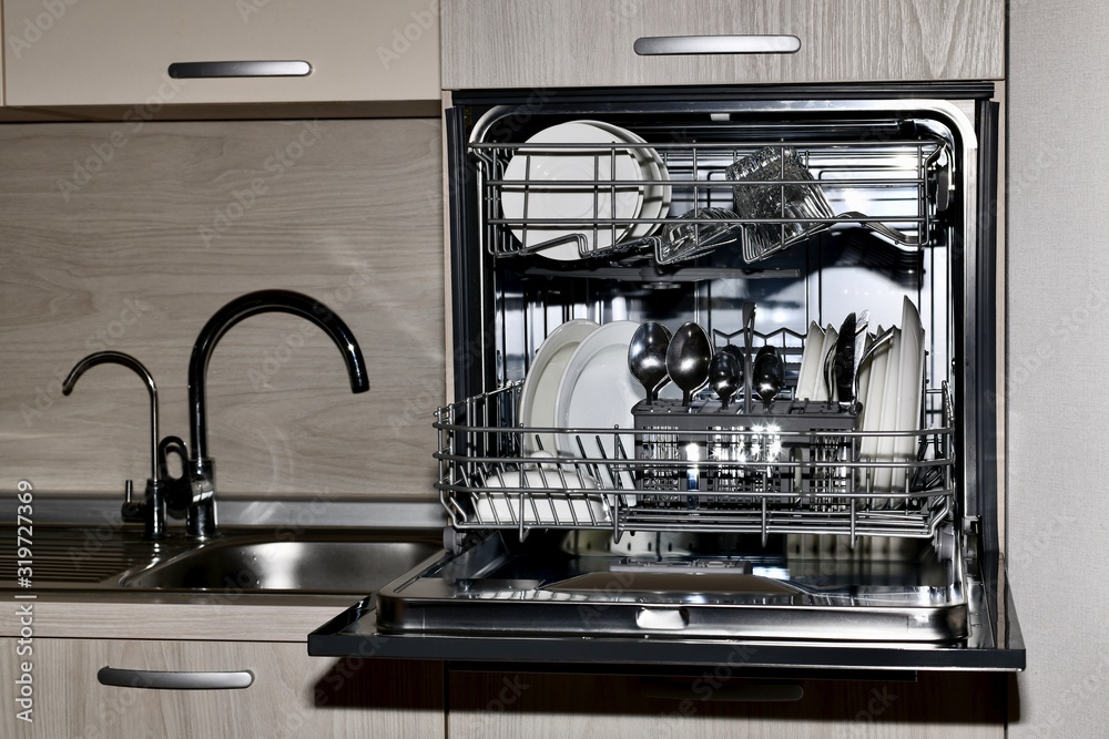 Dishwasher with dishes, built at the sink level with dryer and two taps with tap water and filtered, front view. Dishwasher with dishes, built at the sink level with dryer and two taps with tap water and filtered, front view.