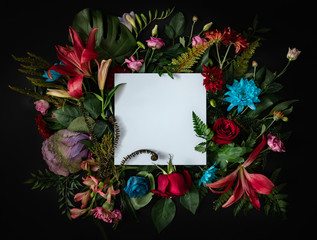 Creative layout made of flowers and leaves. Flat lay. Nature concept. Floral Greeting card. Colorful spring flower background with paper card note. Nature Trendy  Decorative Design.