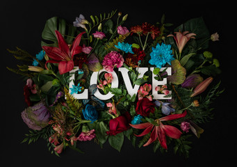 Colorful love background. Floral Greeting card. Happy Women's Day. Spring flower flat lay holiday background with word Love. Nature Trendy Design. Happy Valentine's Day.