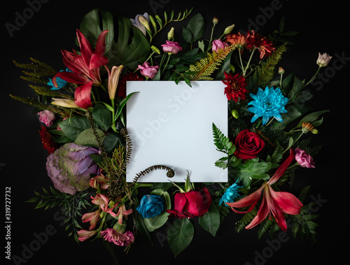 Creative layout made of flowers and leaves. Flat lay. Nature concept. Floral Greeting card. Colorful spring flower background with paper card note. Nature Trendy  Decorative Design.