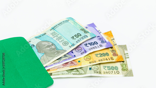 The brand new Indian currency bank notes of 50, 100, 200 and 500 rupees, New Indian Currency  in green envelope on white background, Success and got profit from business