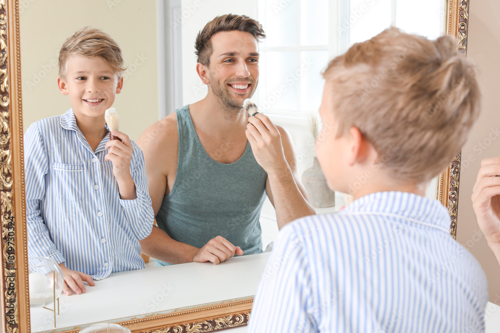 Father with son applying shaving foam onto their faces in bathroom Father with son applying shaving foam onto their faces in bathroom