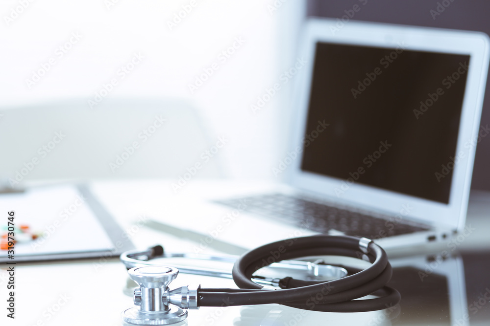 Stethoscope, prescription medical form lying on glass table with laptop computer. Medicine or pharmacy concept. Medical tools at doctor working table Stethoscope, prescription medical form lying on glass table with laptop computer. Medicine or pharmacy concept. Medical tools at doctor working table