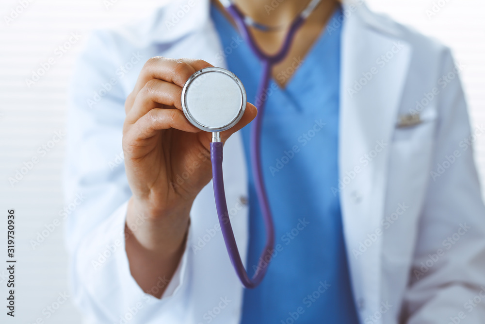 Unknown doctor woman holds stethoscope head, close-up. Physician ready to examine and help patient. Helping and insurance in health care, best treatment and medicine concept Unknown doctor woman holds stethoscope head, close-up. Physician ready to examine and help patient. Helping and insurance in health care, best treatment and medicine concept