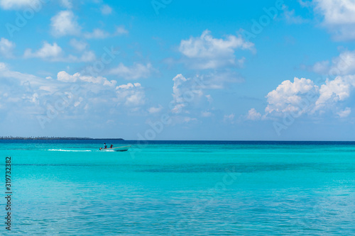 Beautiful Beach Nature Scenery of Maldive Funadhoo Island colorful sea and blue cloudy sky with alone boat Luxury travel summer holiday background concept © sarath