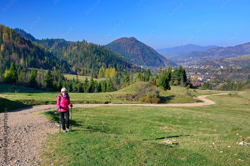 Woman hiking in Pieniny Mountains  on a footpath in sunny autumn day, Szczawnica, Poland