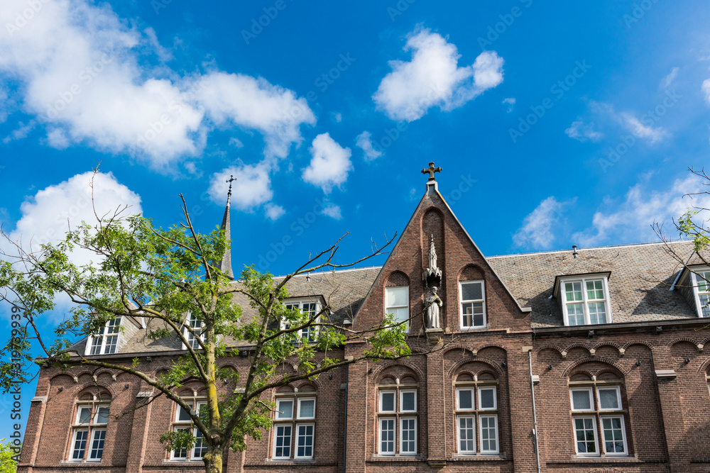 Fototapeta premium facade of historical building with sculpture and towers in Woerden, The Netherlands