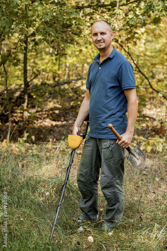 Fototapeta premium Man with electronic metal detector device, outdoor background.