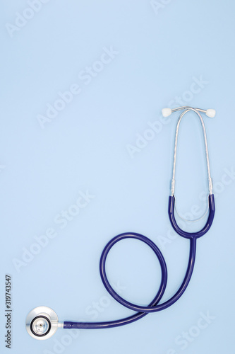 Flat lay of stethoscope for doctor checkup on light blue background with copy space, healthcare and medical concept, top view photo.
