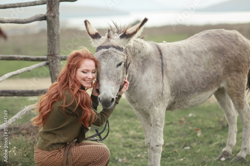 A woman in rural scene on the donkey farm. © ElenaBatkova