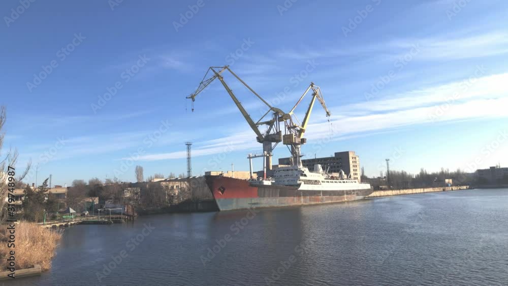 Shipbuilding Dock Near a River Port on a Sunny Day - Slow Motion Tilt Footage Shipbuilding Dock Near a River Port on a Sunny Day - Slow Motion Tilt Footage