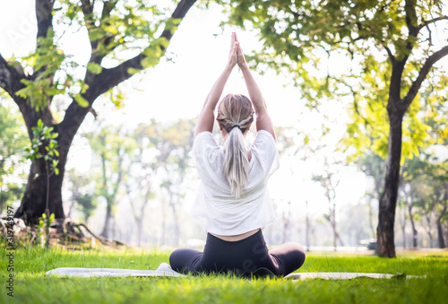 Portrait of young woman practicing yoga in garden.female happiness. blurred background.Healthy lifestyle and relaxation concept.Young Asian Girl doing yoga in the park © anon