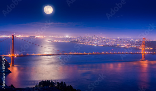 фотография Illuminated Golden Gate Bridge Over Sea Against Full Moon At Night