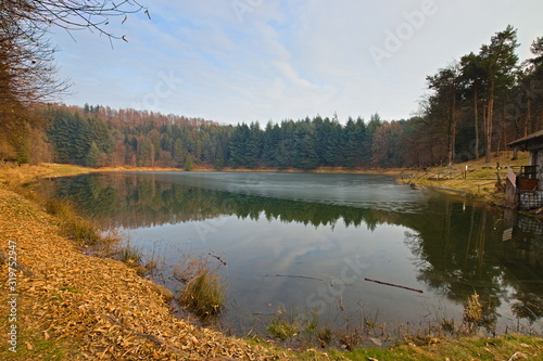 Meugliano lake is a moraine lake of the Ice Age, located in Meugliano, in Valchiusella, Piedmont, Italy. Seen at the sunset of a sunny winter day.