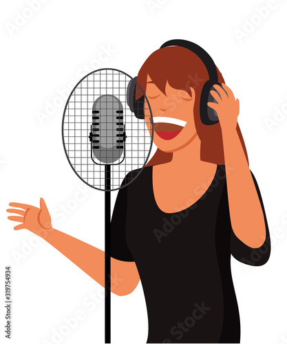 Young woman in headphones singing song in microphone