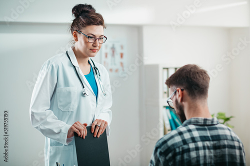 Woman Doctor reads results to Young Patient