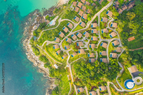 Aerial panorama of tropical resort territory and beach, beautiful Andaman sea at west coast of Phuket Island. Kata Noi beach from above, some buildings and green hills, calm sea surface to horizon photo