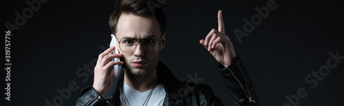 Картината върху платно tense stylish man in leather jacket talking on smartphone and showing idea gestu