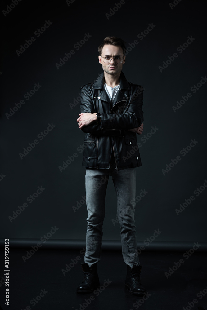 stylish brutal man posing in biker jacket on black stylish brutal man posing in biker jacket on black