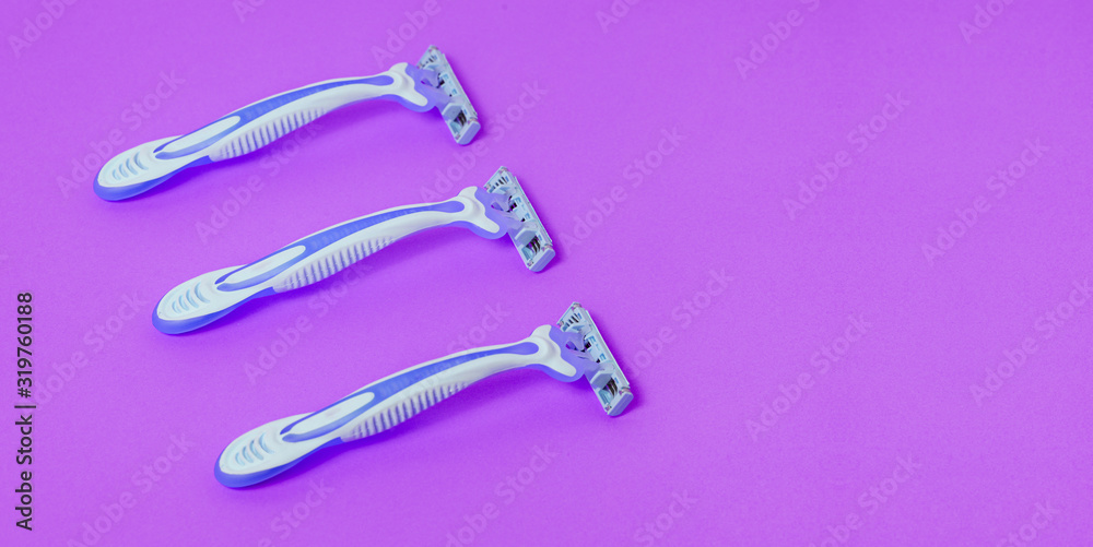 Disposable female razor on a purple background. A tool to remove hair