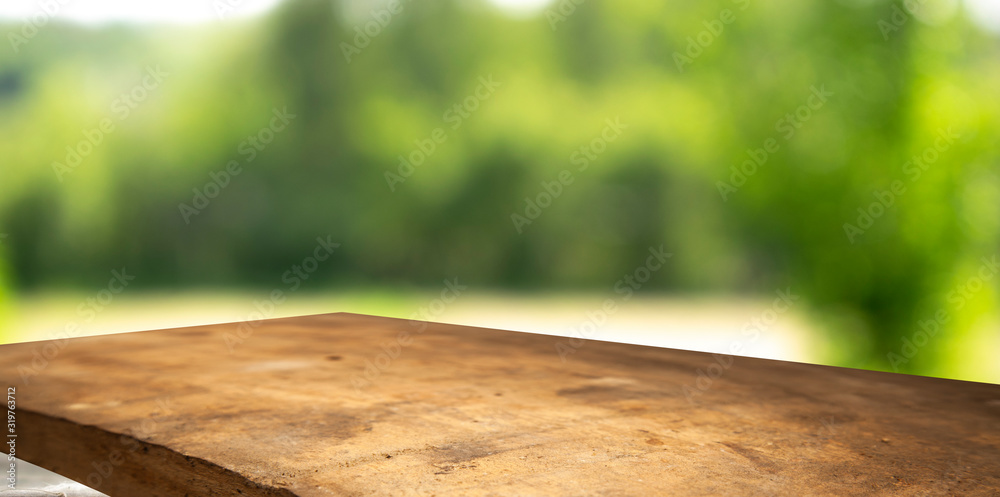 Table top made of old wood on a background of green nature, is available for product, empty background. Table top made of old wood on a background of green nature, is available for product, empty background.