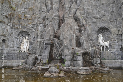 God Triton and ichthyic Centaur blows a bugle, sculpture ancient Roman God messenger of the deep. Sons of Neptune and Salacia. Water cascades Wilhelmshohe mountain Park, Kassel photo