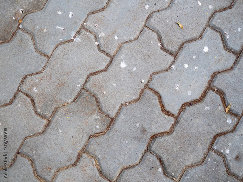 Concrete grey tile filled with heavy brown dirt between space
