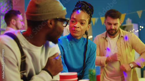 Positive black best friends talking about life at holiday party night. Attractive young couple enjoying eachother company socializing on weekend celebration.