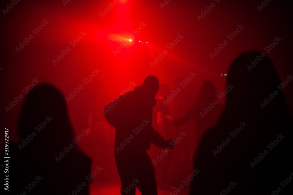 people dancing to electronic music in dark club