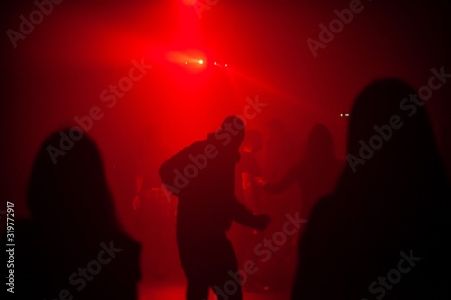 people dancing to electronic music in dark club