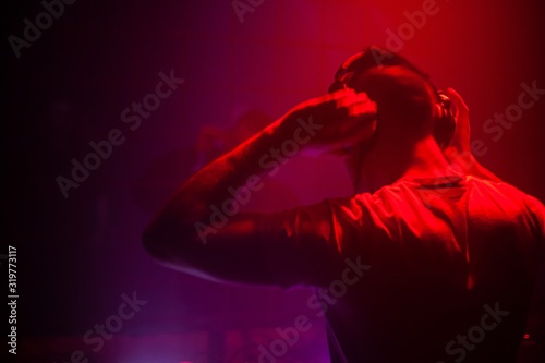 Fotografie DJ performing electronic music for a live audience in a dark club