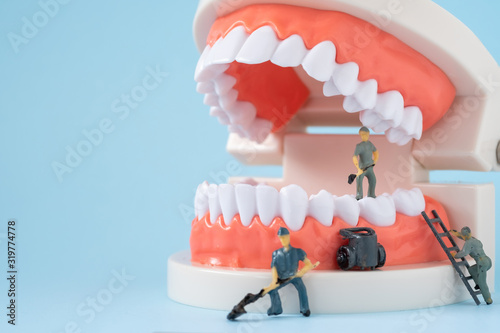Miniature people of the teeth cleaning workers are medical and health care concepts.