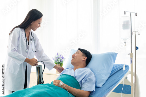 The doctor is the pressure gauge. The patient is lying in a hospital bed.female doctor with happy patient at the hospital.