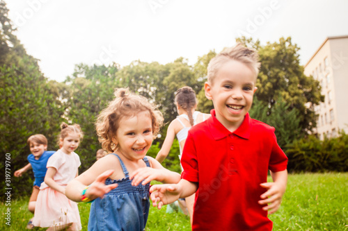 Children run and play on a meadow on a children s birthday party