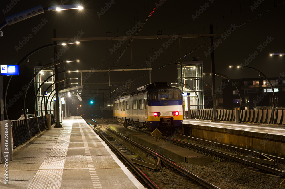 Fototapeta premium Train is waiting on platform at night