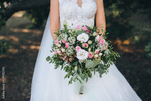 Beautiful wedding bouquet in bride's hands. White and pink roses. Fine art.