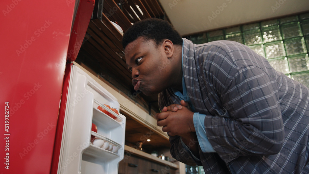 Comical african american funny man in the kitchen screwing his lips and ...